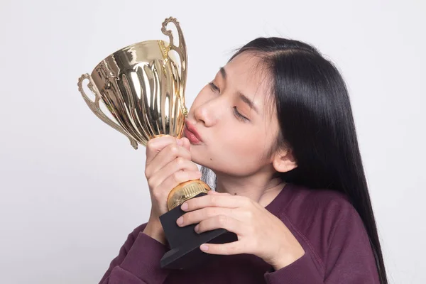Succesvolle jonge Aziatische vrouw met kussen een trofee. — Stockfoto