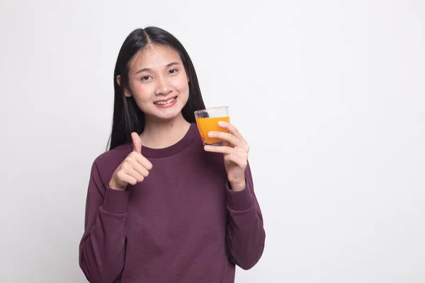 Junge asiatische Frau Daumen nach oben trinken Orangensaft. — Stockfoto