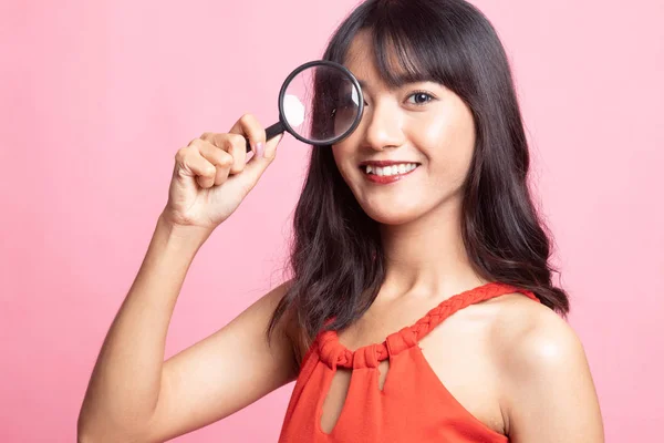 Young Asian woman with a magnifying glass. — Stock Photo, Image
