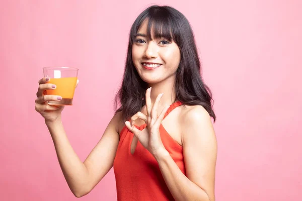 Young Asian woman show OK drink orange juice. — Stock Photo, Image