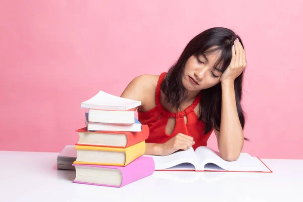 Wyczerpany młoda kobieta azjatyckich czytać książki z książek na stole. — Zdjęcie stockowe