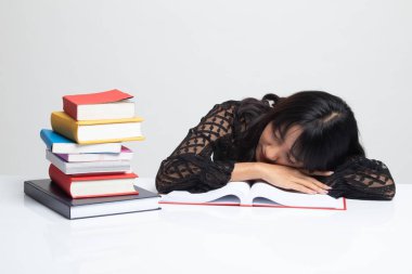 Genç Asyalı kadın uyku tablo kitapları ile yorgun.