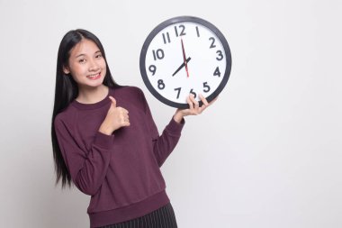 Genç Asyalı kadın başparmak yukarıya ile bir masa saati.