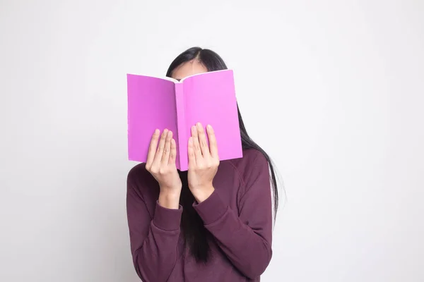 Junge asiatische Frau mit einem Buchdeckel ihr Gesicht. — Stockfoto