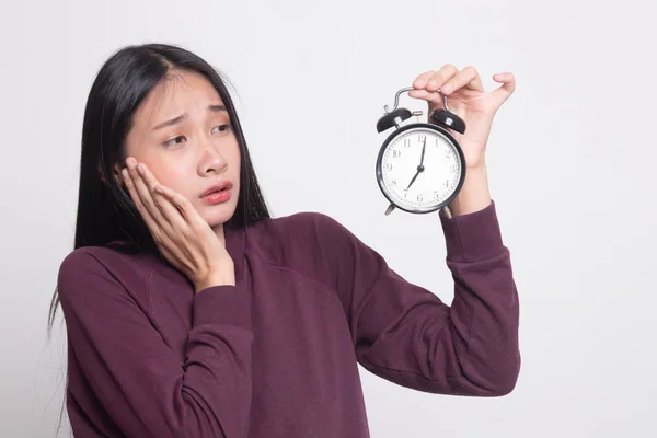 Jonge Aziatische vrouw wordt benadrukt met een klok. — Stockfoto