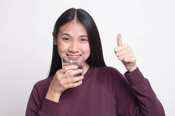 Junge asiatische Frau Daumen nach oben mit einem Glas Trinkwasser. — Stockfoto