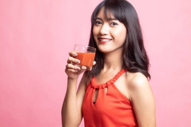 Genç Asyalı kadın içki domates suyu.
