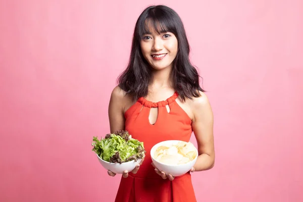 Jovem mulher asiática com batatas fritas e salada . — Fotografia de Stock