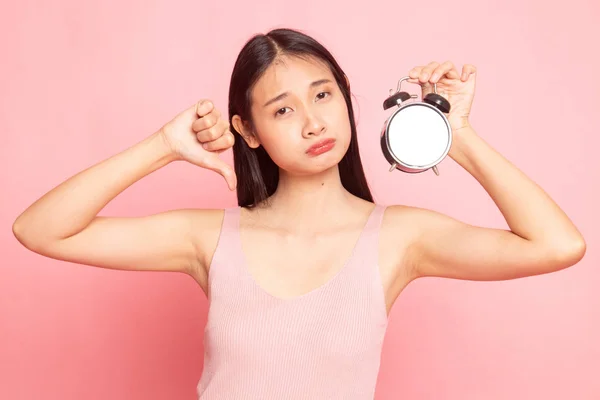 Junge asiatische Frau Daumen nach unten mit einer Uhr. — Stockfoto