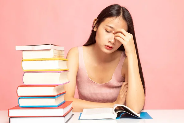 Erschöpfte Asiatin bekam Kopfschmerzen, als sie ein Buch mit Büchern las — Stockfoto