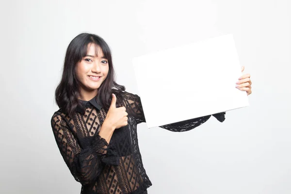 Mladá asijská žena objeví palce s bílým prázdný znak. — Stock fotografie
