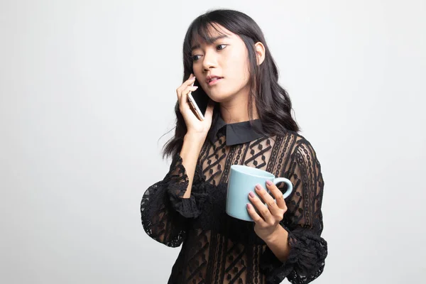 Mujer asiática joven con teléfono móvil y taza de café . — Foto de Stock