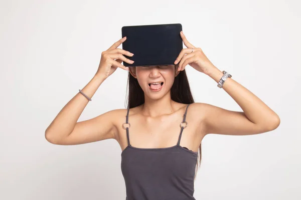 Young Asian woman with a computer tablet over her face. — Stock Photo, Image