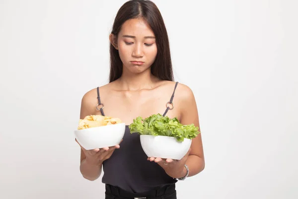 Jonge Aziatische vrouw met aardappel frites en salade. — Stockfoto