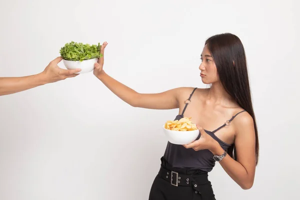 Young Asian woman with potato chips say no to salad. — Stock Photo, Image