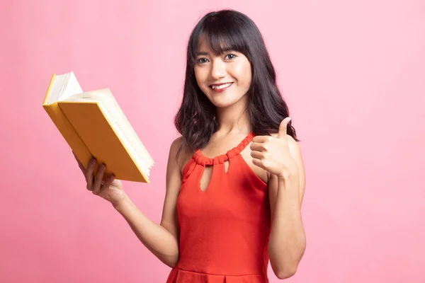 Jovem mulher asiática polegares para cima com um livro . — Fotografia de Stock