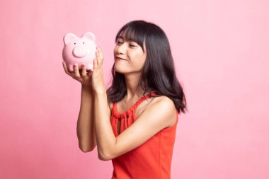 Genç Asyalı kadın öpücük pembe para banka.