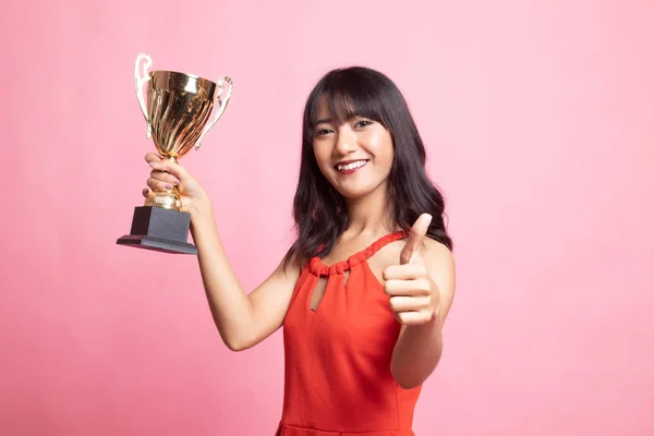 Bem sucedido jovem ásia mulher segurando um troféu mostrar polegar para cima . — Fotografia de Stock