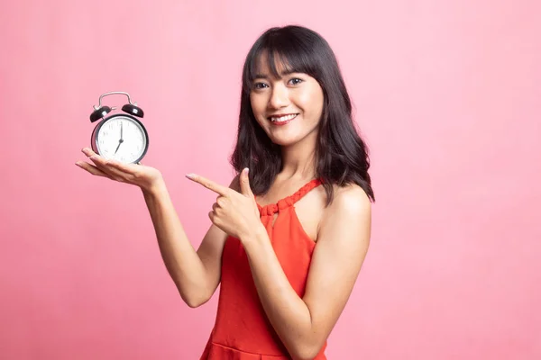 Jeune femme asiatique pointent vers une horloge . — Photo