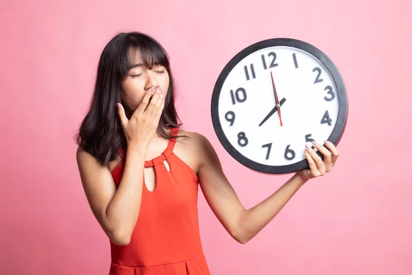 Sleepy joven asiática mujer con un reloj en la mañana . — Foto de Stock