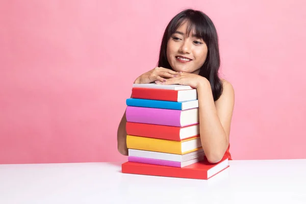 Feliz joven asiática mujer leer un libro con libros en la mesa . —  Fotos de Stock