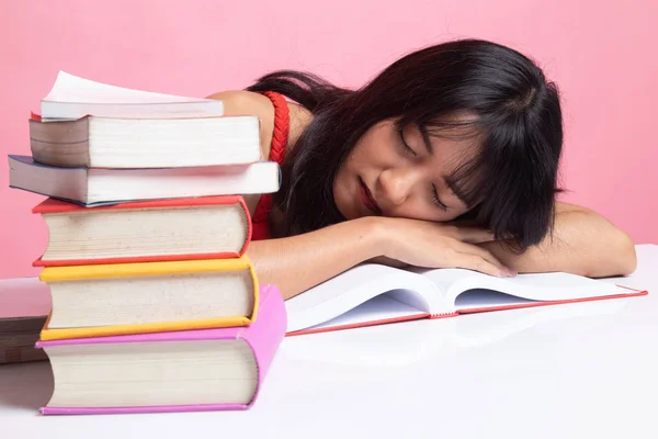 Esausto giovane donna asiatica dormire con libri sul tavolo . — Foto Stock