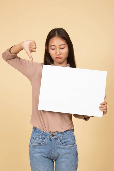 年轻的亚裔女子将拇指下来带白色空白标志. — 图库照片