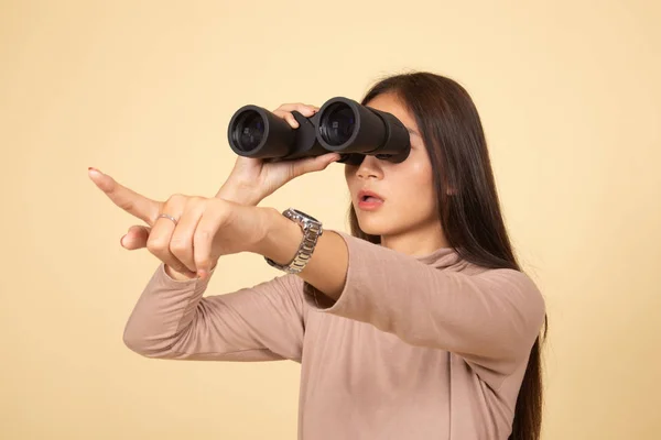 Mladá asijská žena bod a vzhled s dalekohledem. — Stock fotografie