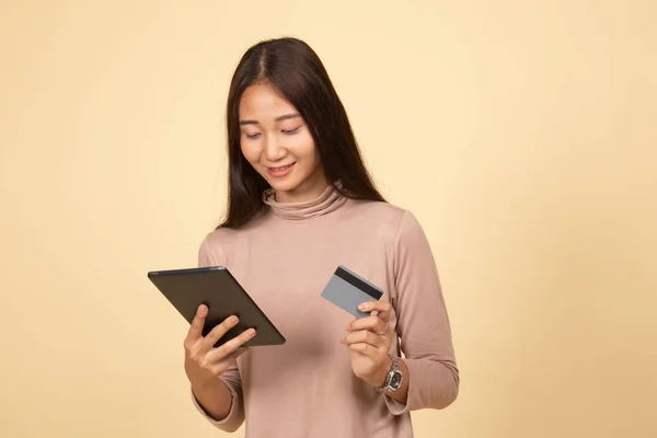 Jonge Aziatische vrouw is online winkelen met creditcard en tablet — Stockfoto