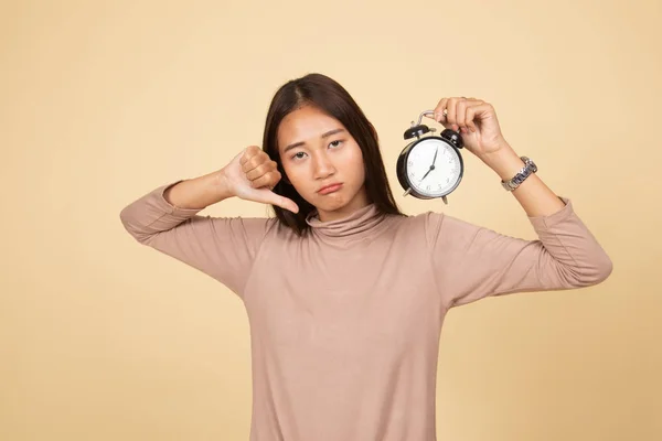 Mladá asijská žena palec dolů s hodinami. — Stock fotografie