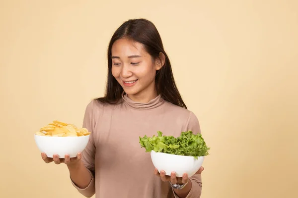 Молодая азиатка с чипсами и салатом . — стоковое фото