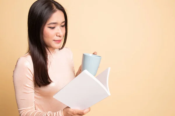 Mladá asijská žena s knihou a šálek kávy. — Stock fotografie
