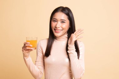 Mutlu genç Asyalı kadın içki portakal suyu.