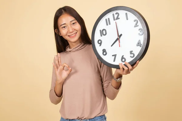 Joven asiática show OK con un reloj . —  Fotos de Stock