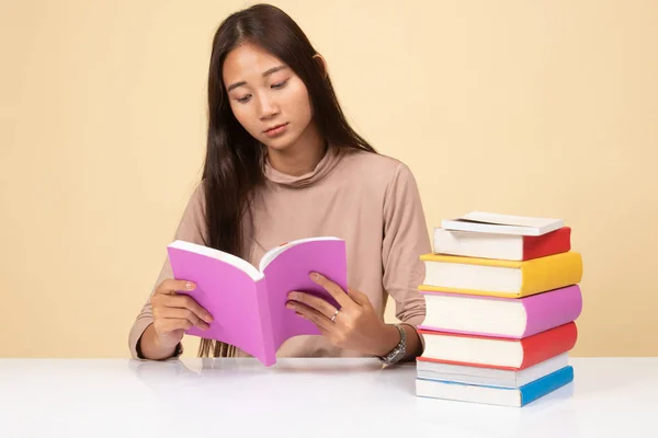 Giovane donna asiatica leggere un libro con libri sul tavolo . — Foto Stock