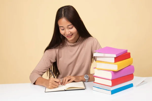 Giovane donna asiatica leggere un libro con libri sul tavolo . — Foto Stock