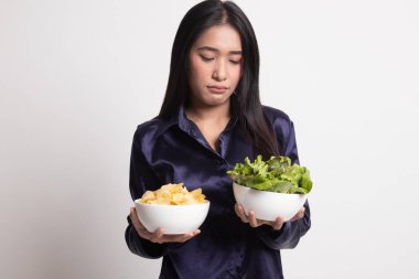 Patates kızartması ve salata ile genç Asyalı kadın.