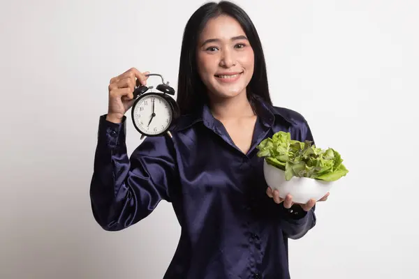 Ung asiatisk kvinna med klocka och sallad. — Stockfoto