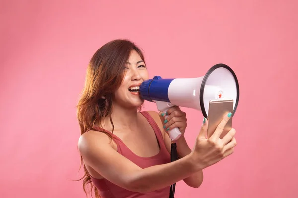 Boze jonge Aziatische vrouw schreeuwen met megafoon naar mobiele telefoon. — Stockfoto