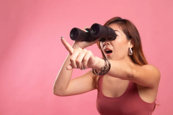 Young Asian woman  point and look with binoculars.