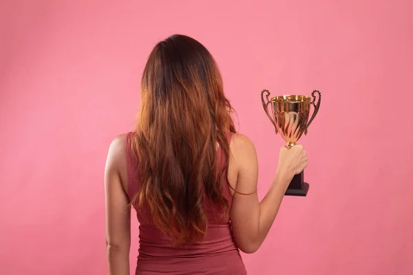 Voltar visão de sucesso jovem asiático mulher segurando um troféu . — Fotografia de Stock