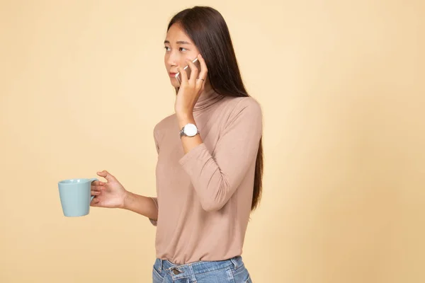 Giovane donna asiatica con telefono cellulare e tazza di caffè . — Foto Stock