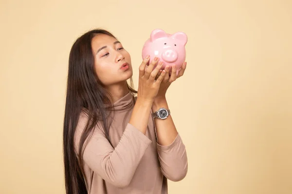 Mladá asijská žena kiss růžová mince banka. — Stock fotografie