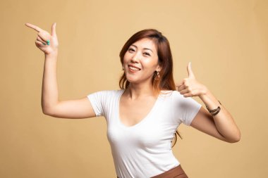 Genç Asyalı kadın noktası ve başparmak yukarıya.