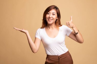 Güzel genç Asyalı kadın göstermek palm el ve başparmak yukarıya.