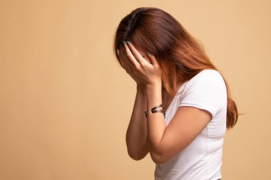 Üzgün genç Asyalı kadın avuç içi ağlar.