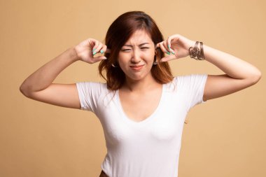 Genç Asyalı kadın parmakları ile her iki kulak engellemek.