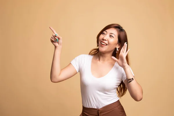 Emocionado asiático mujer punto a espacio en blanco . —  Fotos de Stock