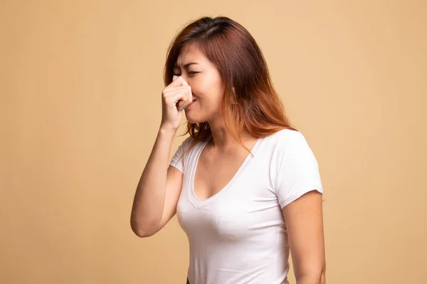 Ung asiatisk kvinna hålla hennes näsa på grund av dålig lukt. — Stockfoto