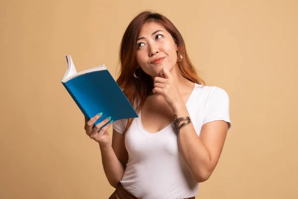 Giovane donna asiatica con un libro sta pensando . — Foto Stock